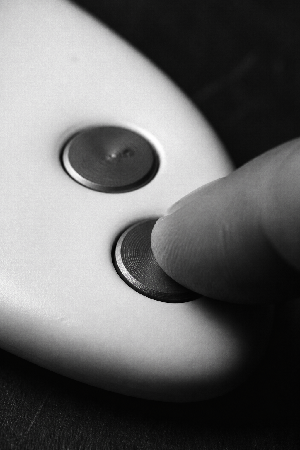 A finger pressing a brass button